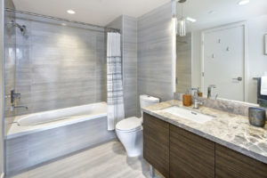 Modern and stylish bathroom design with marble vanity cabinet and gray tiling in a luxury apartment. Northwest, USA