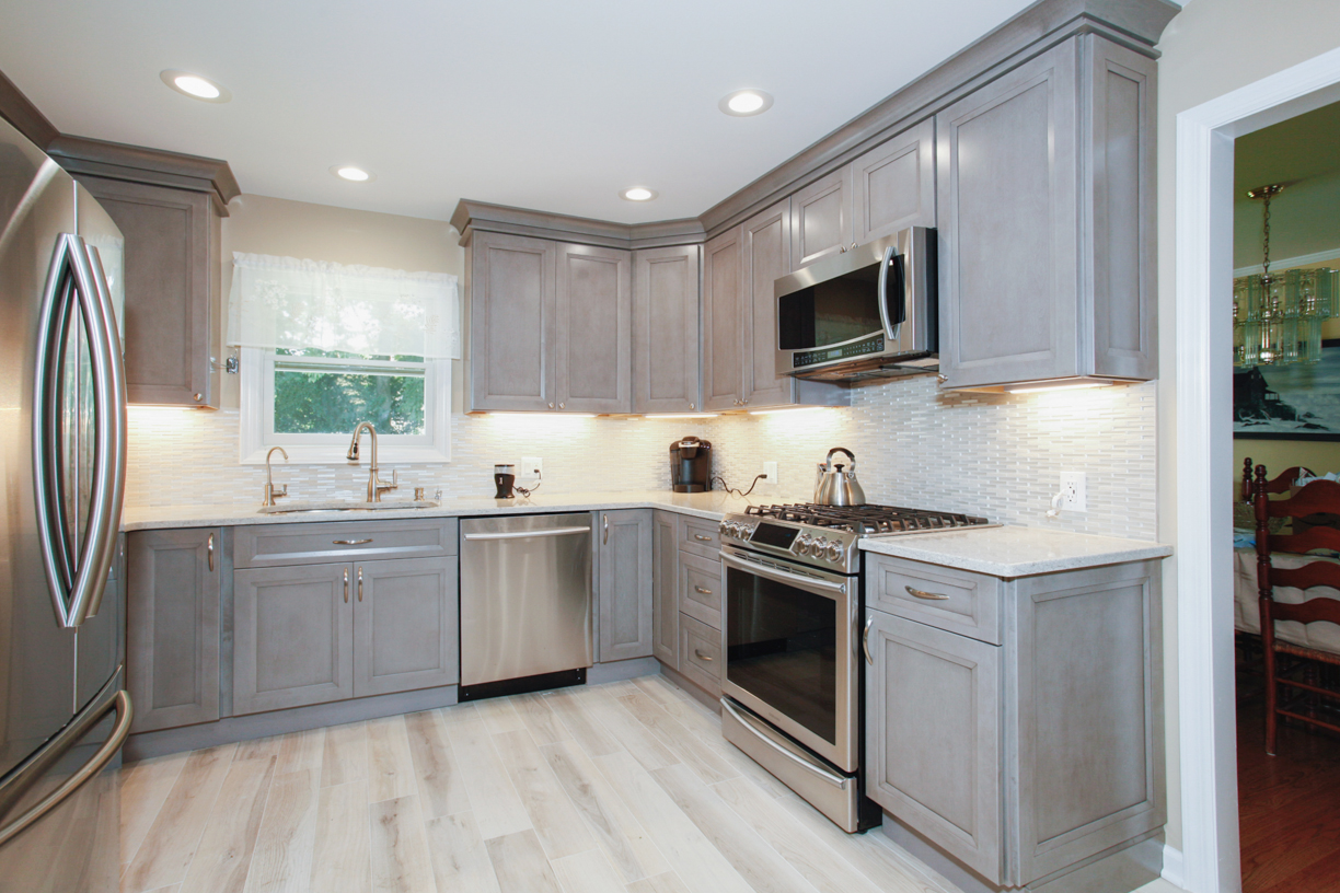 The team of professional contractors at Tandem Contracting completed this kitchen renovation. This kitchen features stainless steel appliances, new countertops, new cabinets, and an updated wood floor.